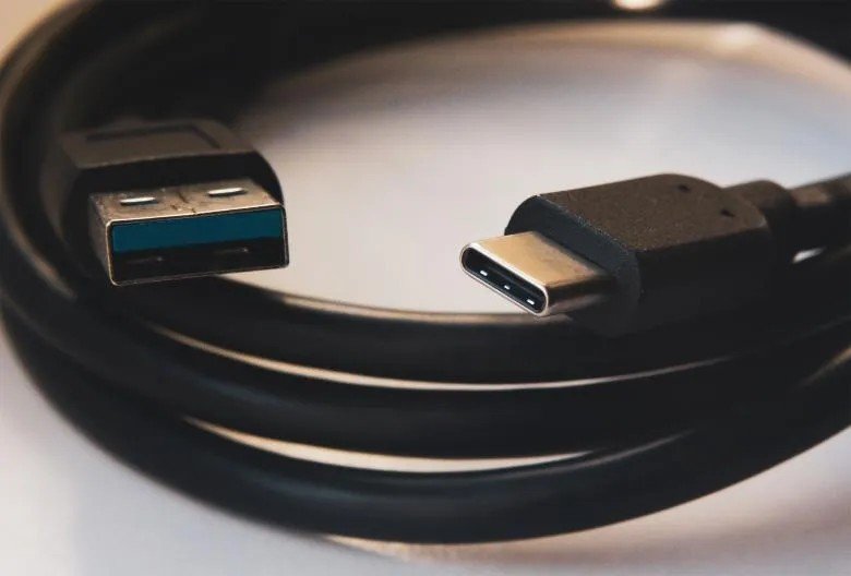 Cavo USB da Tipo-A a Tipo-C arrotolato su una superficie.